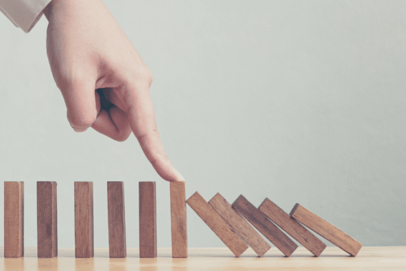 MetroHR Building Resilience Crisis Management Finger holding falling wooden blocks up