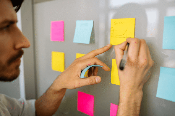 Neurodiversity brings problem solvers and creative thinkers - man writing colourful post it notes