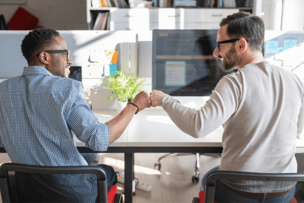 Two colleagues pumping fists - happy workplace
