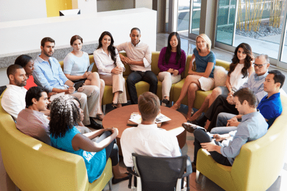 Office team sat in a circle having a meeting - building connection